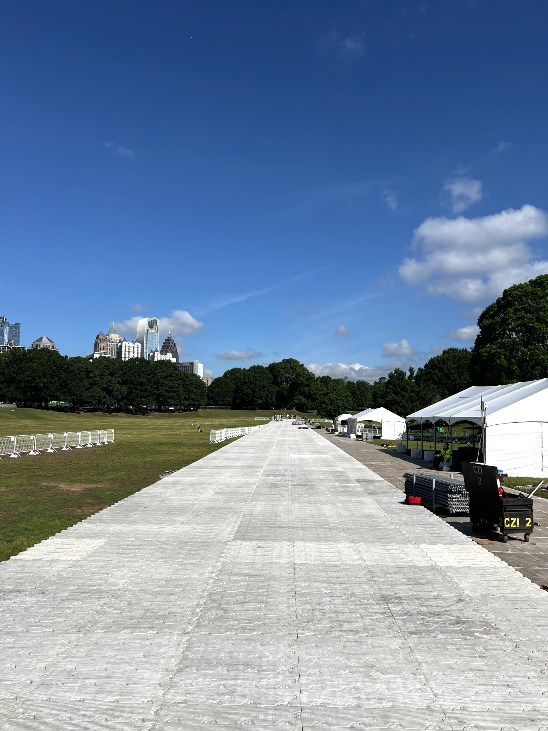 Protective flooring in field with tents.