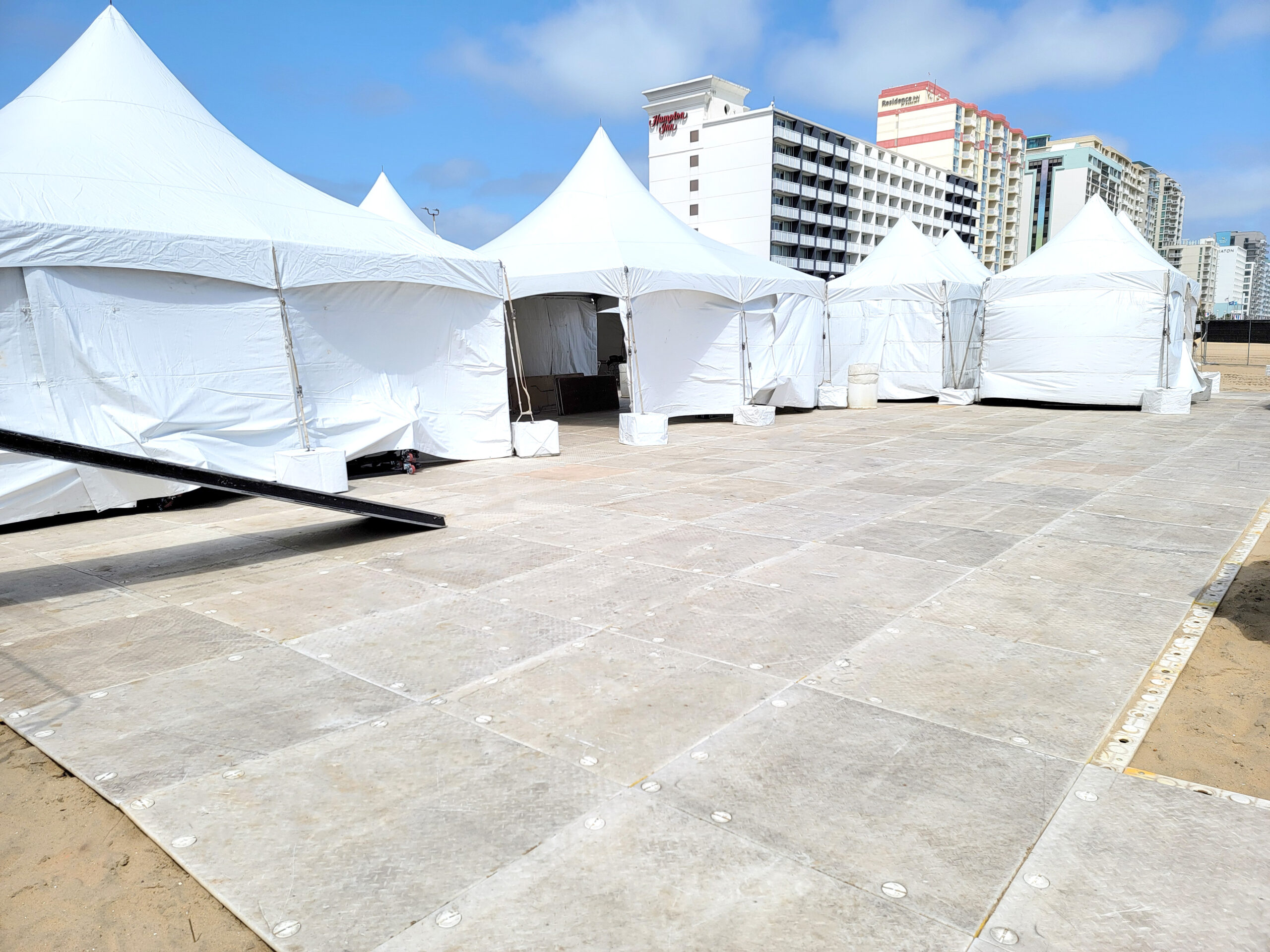 Audacy' Oceanfront Concerts - Virginia Beach - pop up tents for vendors with protective flooring on sand